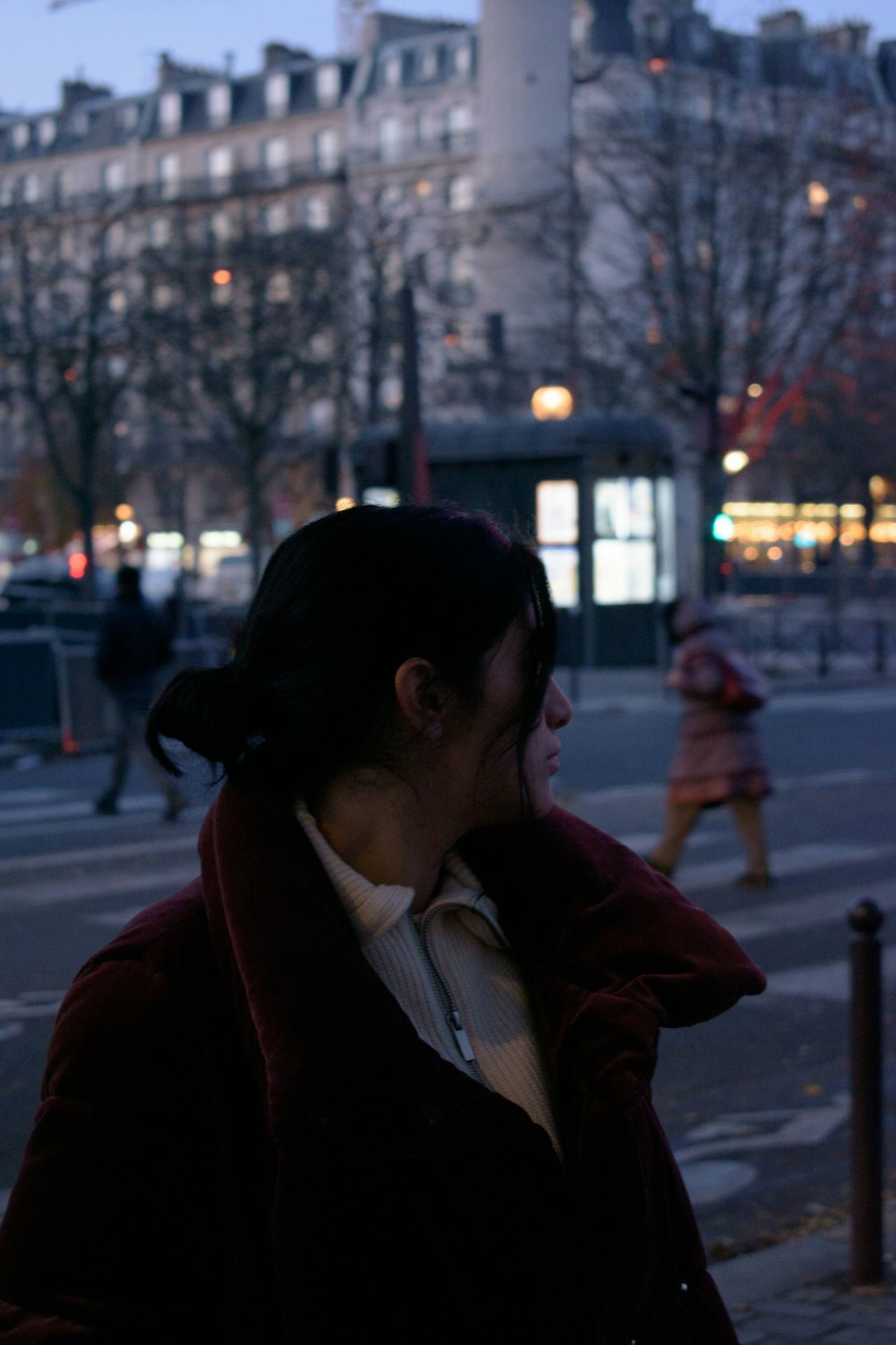 a woman standing on the side of a street